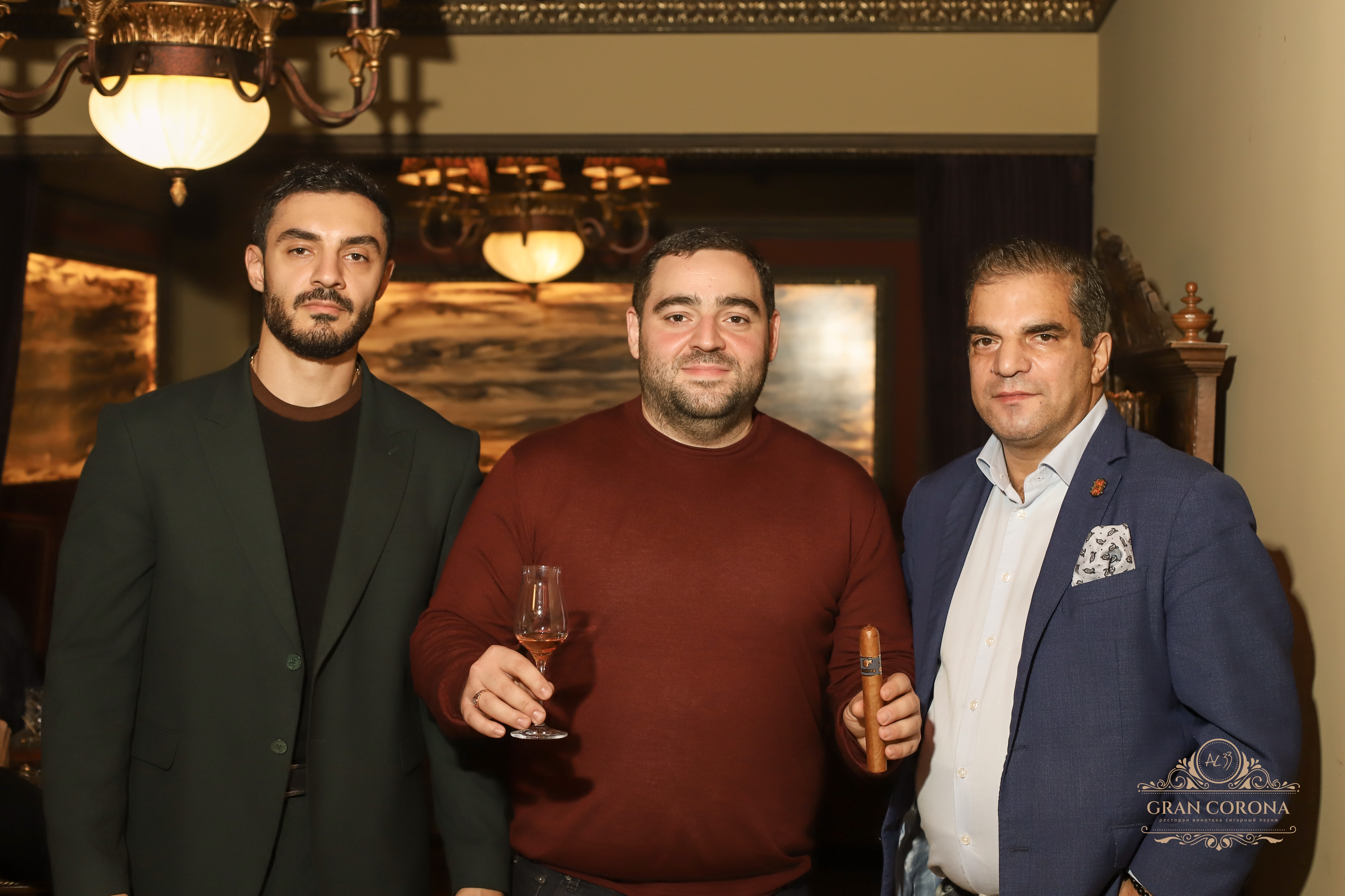 Гости сигарного клуба Gran Corona с бокалом рома и премиальной сигарой Cohiba